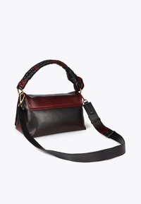 Borsa in pelle con un motivo di colori rosso e nero, forma strutturata, manico intrecciato, cintura rimovibile e dettagli in metallo dorato.