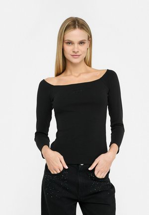 Top nero a maniche lunghe con scollatura off-the-shoulder, caratterizzato da un design aderente e un logo discreto sul petto.