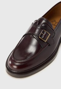 Μπορντό δερμάτινα loafers με στρογγυλεμένη μύτη, διπλό λουράκι με αγκράφα, λεία υφή και χαμηλό, επίπεδο τακούνι.