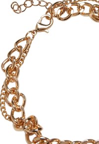 Guldtonet metal kædehalskæde med store led, en tekstureret overflade og en lobster clasp lukning med en justerbar forlængerkæde.