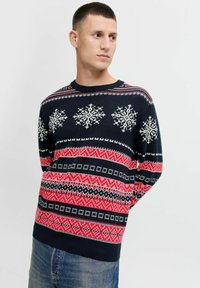 Maglione lavorato a maglia in blu navy con motivi a fiocco di neve bianchi, disegni geometrici rossi e neri. Polsini e orlo a coste, scollo rotondo.