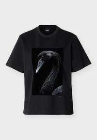 Μαύρο κοντομάνικο μπλουζάκι με μια λεπτομερή, υψηλής αντίθεσης πλευρική όψη ενός μαύρου κύκνου τυπωμένη στο κέντρο μπροστά.