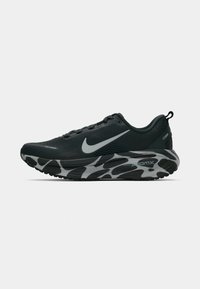 Čierna bežecká obuv Nike s šedým logom swoosh, vzorovanou medzipodrážkou, priedušným sieťovinovým zvrškom a očkom na päte, zobrazená z bočného profilu.