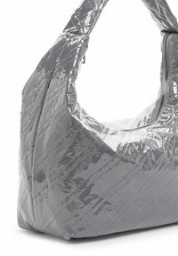 Bolso de patente gris acolchado con un asa ancha y curva y un cierre con cremallera. Presenta una textura brillante con detalles de costura sutiles.