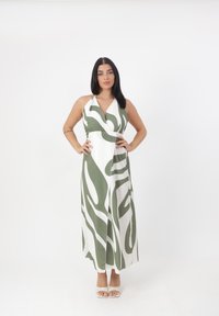 Abito lungo con scollo all'americana, caratterizzato da una base bianca e un motivo astratto a swirl verde. Realizzato in tessuto morbido, lunghezza alla caviglia con vita aderente.