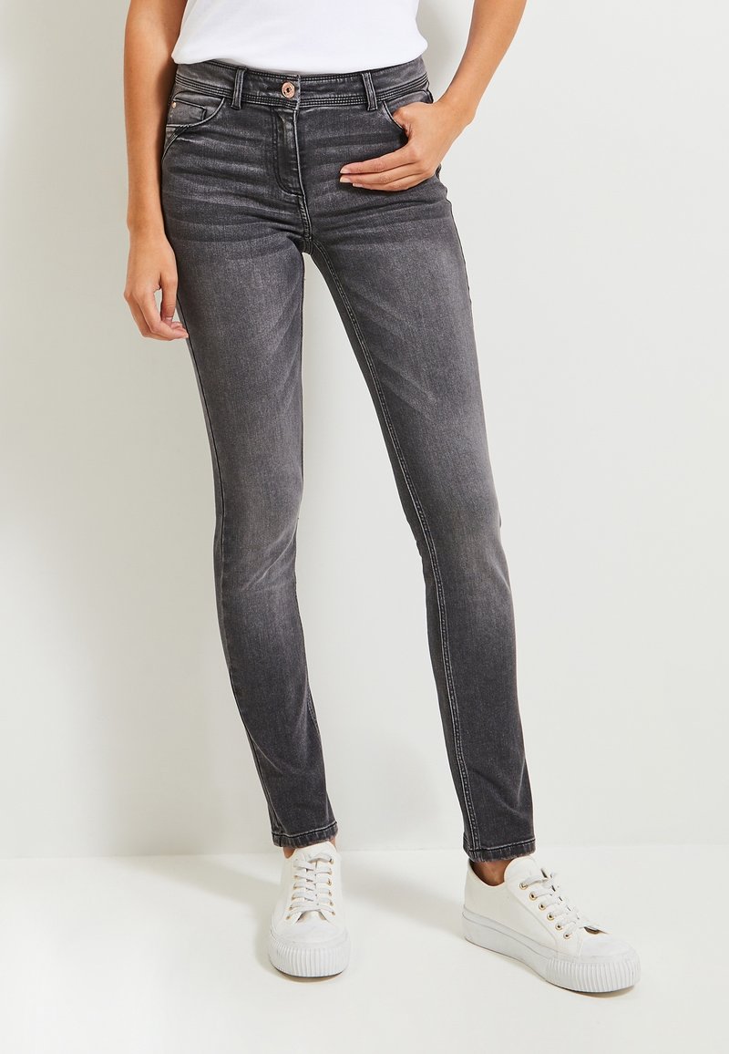 Smala svarta jeans i denim, med en medelhög midja, framfickor och lätt blekning. Matchade med vita sneakers.