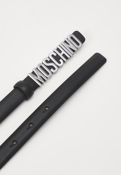 Fekete bőrből készült öv, amelyen egy nagy ezüst logó csat látható, amely a "MOSCHINO" feliratot formázza. Az öv sima felületű és több állítólyukkal rendelkezik.