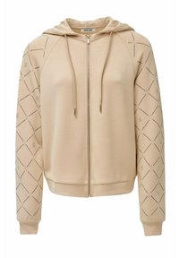 Sudadera con cremallera en color beige, con capucha, que presenta un diseño de patrones de diamante y acentos metálicos en las mangas. Tejido suave, puños y dobladillo acanalados.