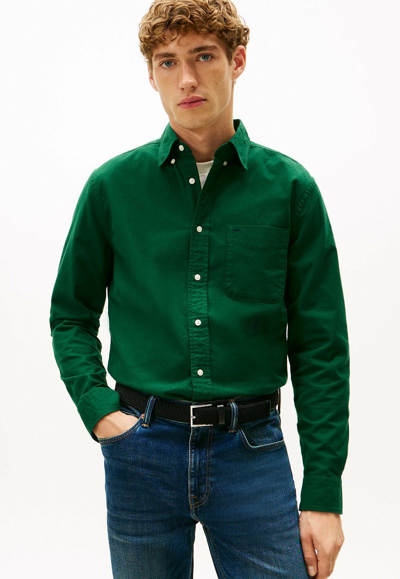 Groene button-up shirt van katoen, met een borstzak en knoopschoenen, gecombineerd met blauwe denim jeans en een zwarte geweven riem.