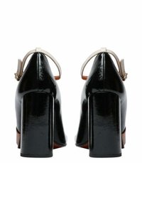 Scarpe con tacco alto in vernice nera con tacco largo a blocco, punta chiusa e cinturino alla caviglia di colore chiaro con dettaglio fibbia.