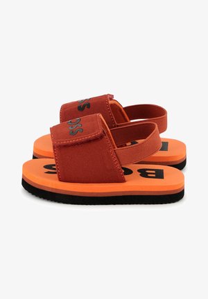 Rode canvas sandalen met een oranje rubberen zool, uitgerust met een klittenbandsluiting en zwarte lettering. Zachte textuur, lichtgewicht ontwerp en casual stijl.