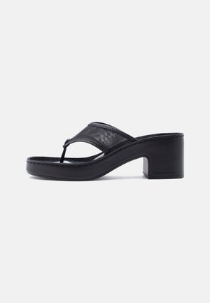 Black heeled thong sandal with a chunky heel and wide mesh strap over the foot on a plain light background.