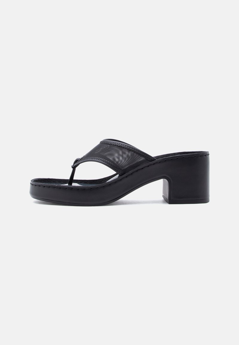 Sandale noire à talon aiguille avec un talon épais et une large bride en mesh sur le dessus du pied, sur un fond clair uni.