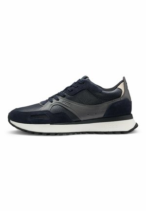 Niskie czarne i ciemnoszare sneakersy z białą podeszwą, teksturowaną skórą i panelami z zamszu, zapinane na sznurowadła, z logo marki po boku i na śródpodeszwie.