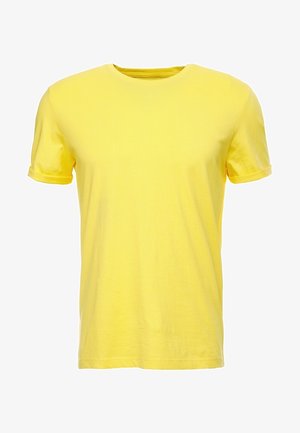 Camiseta lisa amarilla de manga corta con cuello redondo y puños remangados, mostrada sobre un fondo blanco.