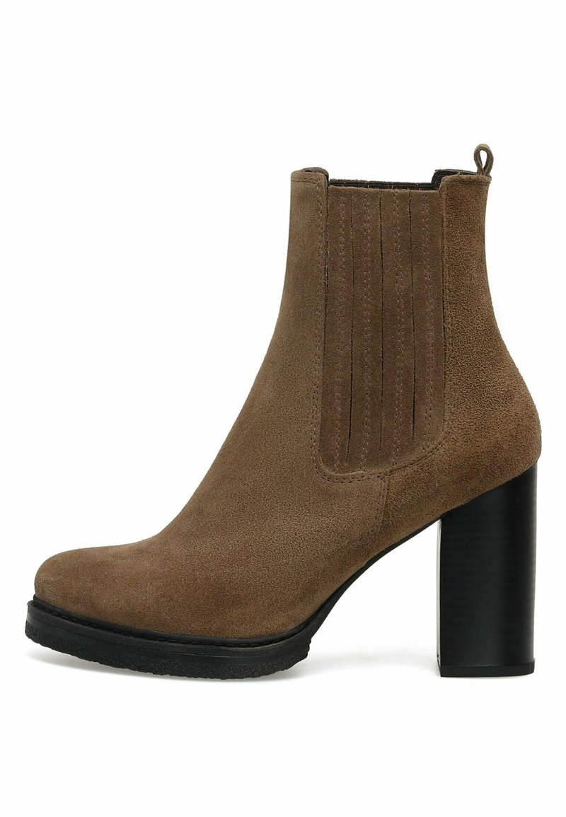 Bottine en daim marron avec panneau latéral élastique, tirant en boucle, bout rond, talon bloc noir empilé et semelle en caoutchouc noir.