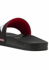 Sort slidesandal med rød inderside, struktureret sål, bred rem og Puma-logo på siden. Lavet af syntetiske materialer.