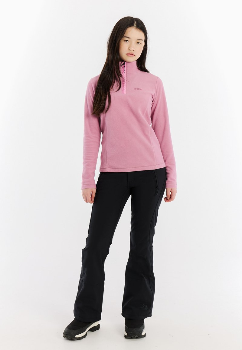 Pullover in pile rosa chiaro con colletto a mezze zip. Abbinato a pantaloni neri a vestibilità slim e stivali invernali neri. Texture liscia, senza fantasie.