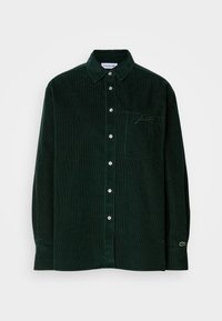 Camicia a maniche lunghe in corduroy verde scuro con chiusura a bottoni, colletto, taschino sul petto, logo ricamato sottile e polsini con bottoni.