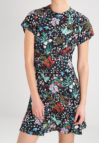 Blommig kortärmad klänning med svart bakgrund, prydd med livfulla mönster i rosa, rött och grönt. Mjuk tyg med en avslappnad passform.