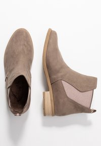Suede ankle boots in taupe with elastic side panels, textured finish, wooden block heel, and round toe design.