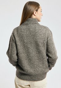 Grijze, gebreide trui met hoge kraag, drop shoulders en ribgebreide manchetten en zoom. Zachte textuur met een casual pasvorm.