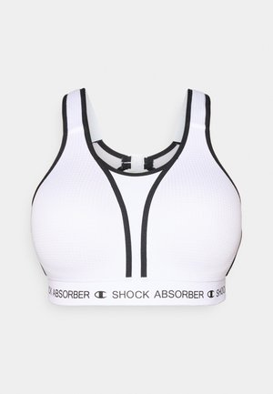 Brassière de sport blanche avec des accents noirs et une texture en mesh. Présente un large sous-bandeau marqué "SHOCK ABSORBER" et des bretelles ajustables.