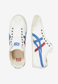 Sneaker bianche con accenti blu e rossi, dotate di tomaia in tela, perforazioni circolari e suola in gomma di contrasto.