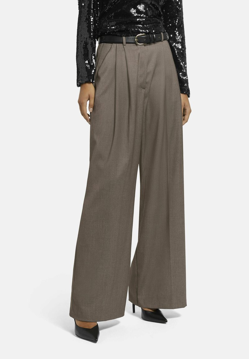 Wijdbenige broek van een gestructureerd, donkerbruin materiaal. Voorzien van voorplooien, een hoge taille en een zwarte riem met een gouden gesp.