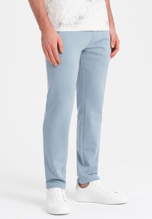 Jasnoniebieskie dresy slim fit z miękkiego materiału, o gładkiej strukturze i elastycznej talii. W połączeniu z białymi trampkami.