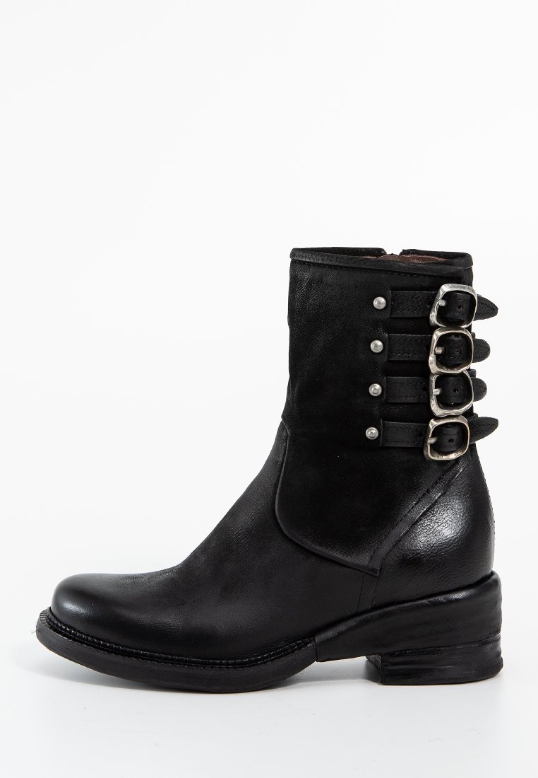 Bottines en cuir noir avec un bout pointu, textures mates et brillantes contrastées, cinq accents de boucles en argent sur le côté et un talon empilé.