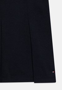 Tessuto di cotone blu navy con una superficie liscia, caratterizzato da un delicato accento di logo in rosso, bianco e blu sull'orlo, e una linea dritta.