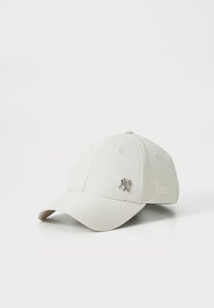 Casquette de baseball minimalist beige clair avec logo en métal des New York Yankees et symbole de la marque New Era brodé sur le côté.