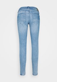 Vaqueros slim-fit de color azul claro con una cintura de altura media. Presenta dos bolsillos traseros, un leve desgaste y un dobladillo cosido. Tejido de mezcla de algodón.