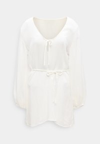 Λευκή μακριά τουνίκ με V-λαιμόκοψη, λεπτομέρεια δέσιμου στην περιοχή του λαιμού και της μέσης, κατασκευασμένη από ελαφρύ υφαντό ύφασμα.