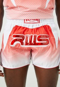 Man wearing red and white patterned athletic shorts with bold shiny red "RWS" lettering on the front.