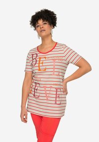 Stripet kortærmet t-shirt i blødt stof med livlige bogstaver i orange, pink og burgunder på en lys baggrund.