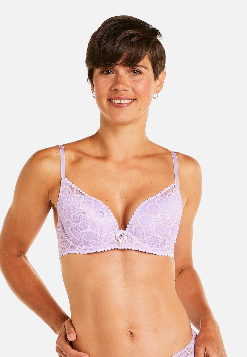 Soutien-gorge en dentelle lilas avec un décolleté plongeant, motif floral, bretelles ajustables, bordures à volants et un petit charm décoratif au centre.