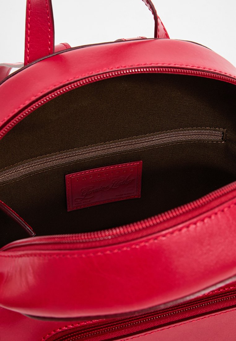 Rote Lederhandtasche, offen, um das dunkle Stoffinnere mit einer Reißverschlusstasche und einem roten Leder-Brandlabel innen zu zeigen.