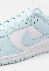 Ljust blå läder sneaker med vita accenter, texturerade paneler, rund tå, snörad design och gummisula med greppmönster.