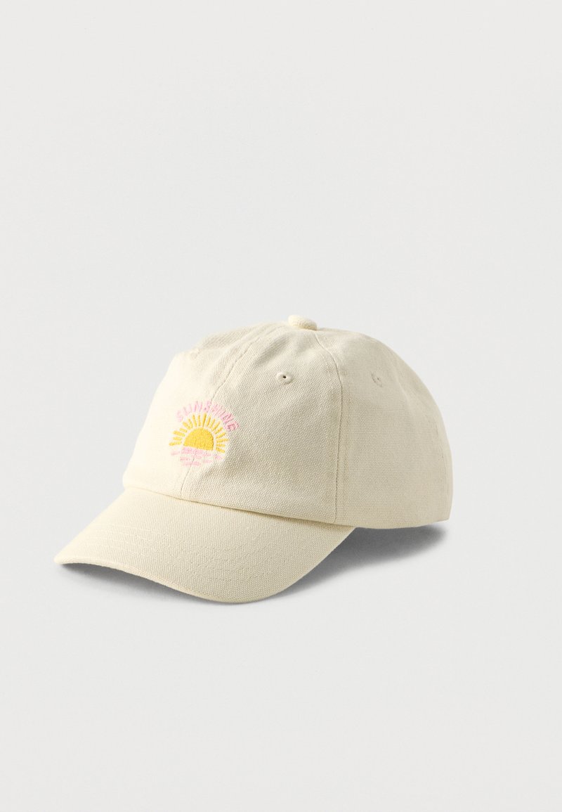 Μπεζ καπέλο μπέιζμπολ με μικρό κεντημένο κίτρινο ήλιο και ροζ κείμενο στο μπροστινό μέρος, εμφανιζόμενο σε φωτεινό φόντο.