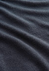 Tesătură de culoare gri închis, cu o suprafață moale și texturată, care prezintă valuri subtile și un model de tricot uniform, potrivită pentru îmbrăcăminte sau tapițerie.