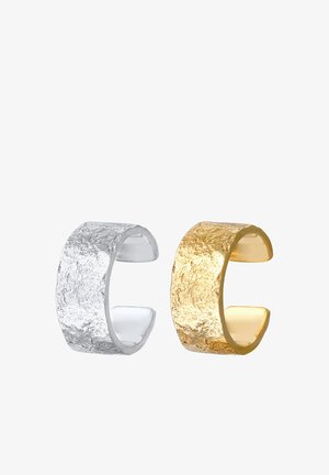 To åbne ringe: den ene sølv med en tekstureret overflade og den anden guld med en lignende tekstur, begge med et bredt bånddesign.