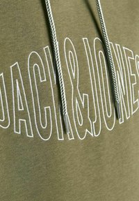 Felpa con cappuccio verde oliva caratterizzata da un grande logo bianco "JACK & JONES", con tiranti testurizzati e punte metalliche che arricchiscono il design.