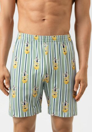 Lichtgroene gestreepte herenshorts met een herhalend patroon van een vrouw zittend binnen een geel spiraalontwerp.