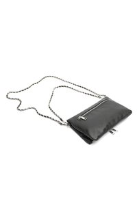 Sac bandoulière en cuir noir avec une bandoulière en chaîne argentée, doté d'une poche zippée et d'une surface texturée. Forme rectangulaire compacte.