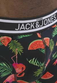 Boxer neri con un motivo di anguria e fenicottero, con una cintura elastica bianca e nera a contrasto etichettata "JACK & JONES."