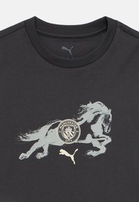 Μαύρο βαμβακερό t-shirt με γραφικό τρέχοντος αλόγου, λογότυπο της Manchester City και λογότυπο Puma σε ανοιχτό γκρι και χρυσές αποχρώσεις.