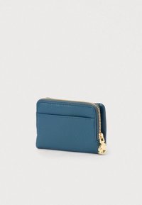 Kompakti sininen nahkalompakko kultaisella vetoketjulla ja pienellä kultaketjulla yksinkertaisella valkoisella taustalla.