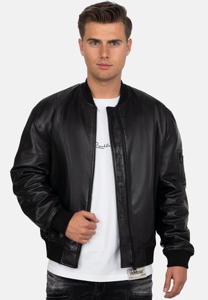 Black leather bomber jacket with a ribbed collar, front zipper, and side pocket accents, worn over a white shirt. Smooth texture, classic design.